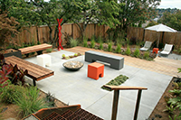 Both terraces are shown here; the upper concrete deck features built in benches and a small portable fire feature. The gravel terrace below is the best location for afternoon sun bathing.