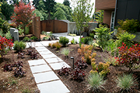 A secondary pathway leads to additional parking and trash bins. The curved steel wall blocks sightlines to the lower private areas and is a play of line and form.