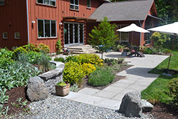 Architectural pavers lead to the front door and expanded patio over their woodland property
